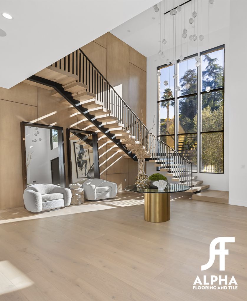 Wide-plank hardwood foyer with floating staircase
